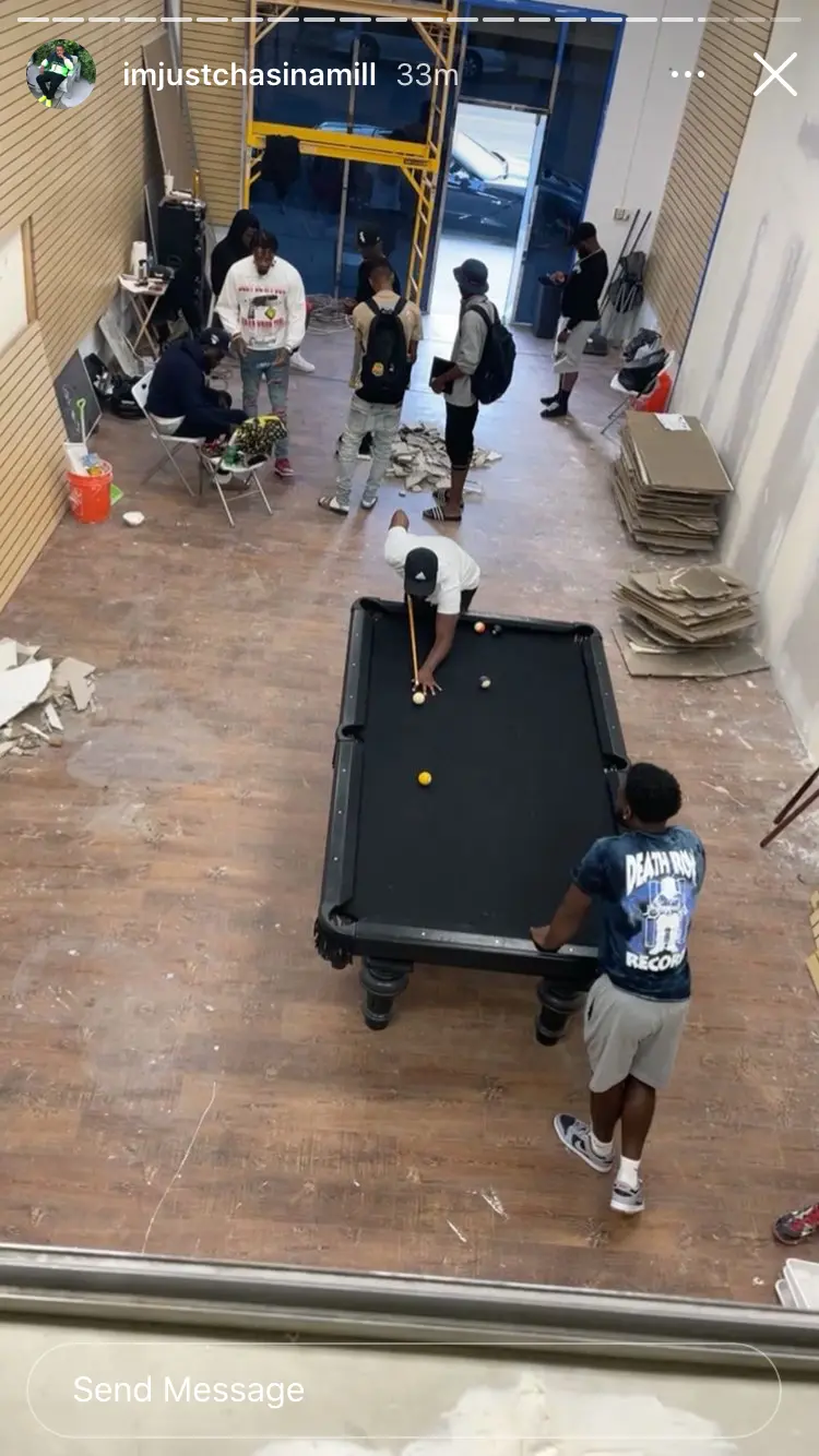 Commercial flooring build-out in progress with a pool table and workers inside the space
