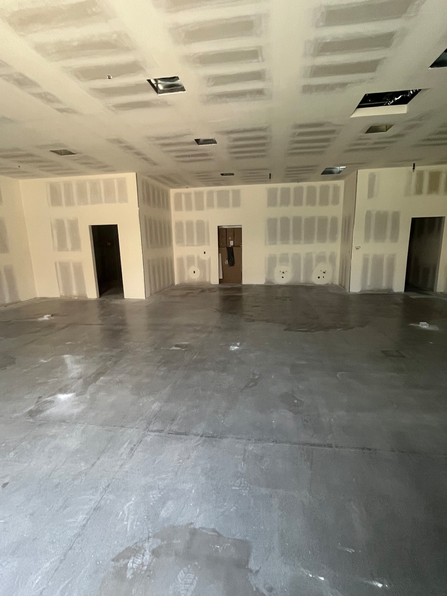 Commercial interior with taped and floated drywall walls and ceiling