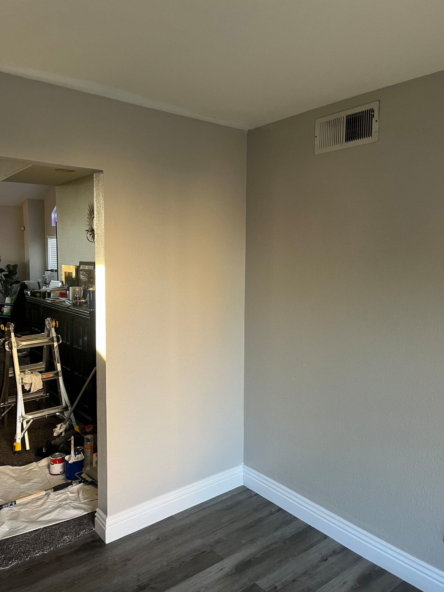 Freshly painted interior walls with finished white baseboards and gray flooring