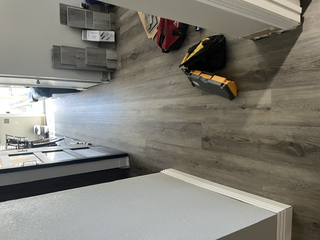 Vinyl plank flooring running down a hallway into an adjoining room