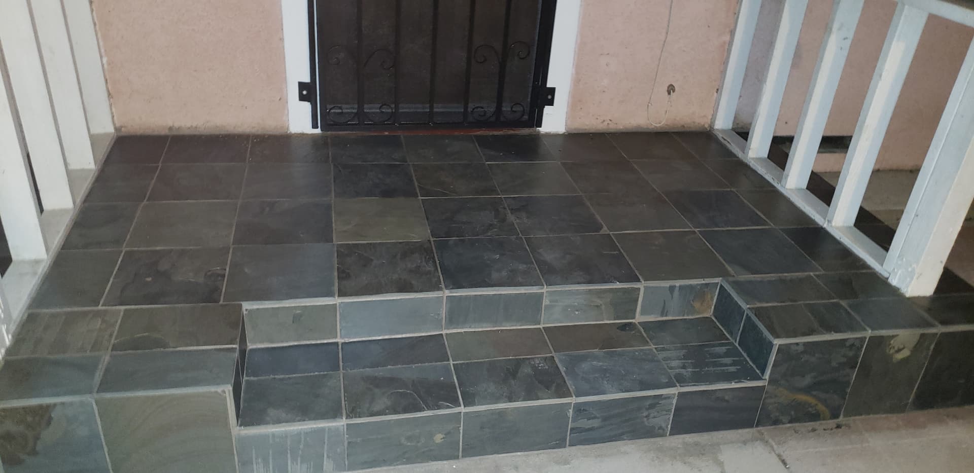 Dark tile porch landing and steps at a home's entry