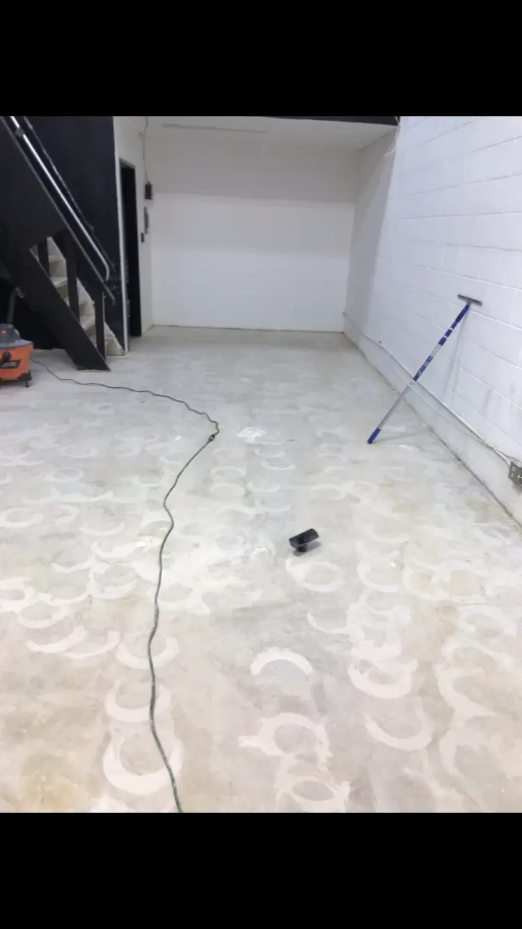 Bare concrete slab ground clean with old adhesive rings still visible before epoxy